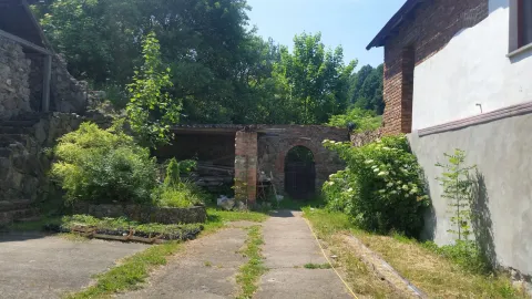 Dziedziniec aszramu z ceglanym przejściem i ogrodem