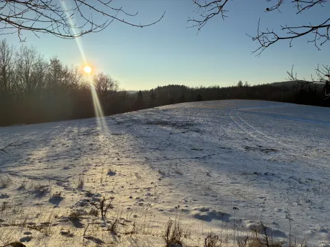 Zimowy krajobraz ze śnieżnymi wzgórzami o zachodzie słońca
